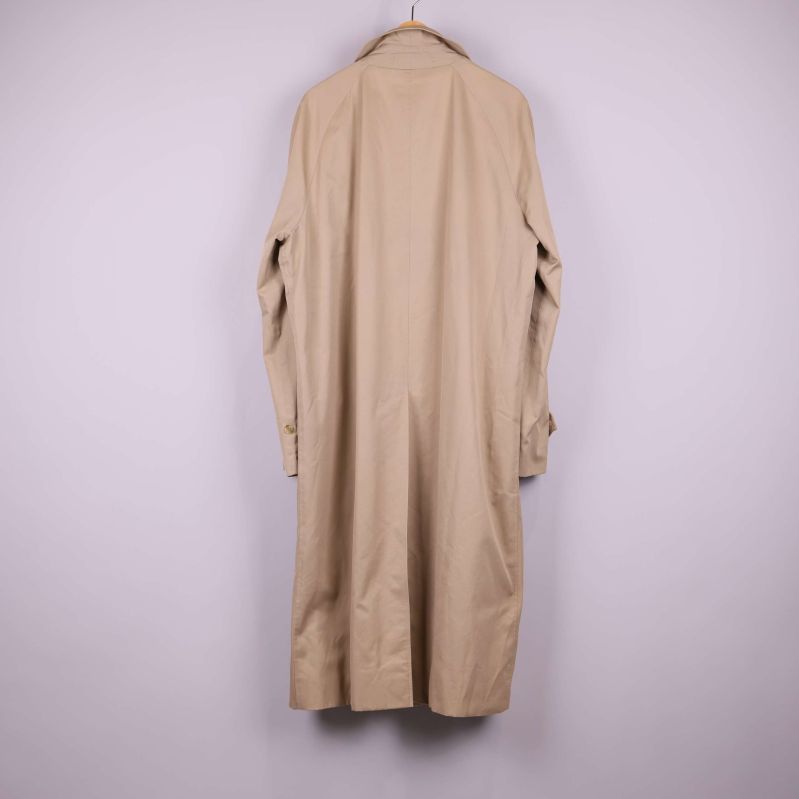 Baksidan av lång beige trenchcoat 