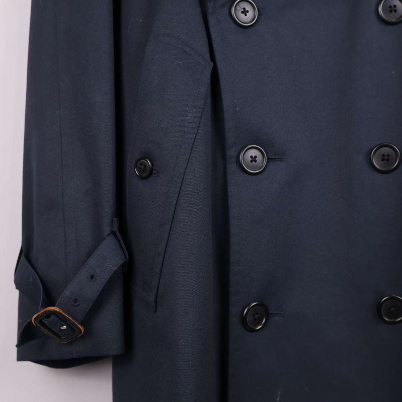 Närbild på ficka och knappar på trenchcoat
