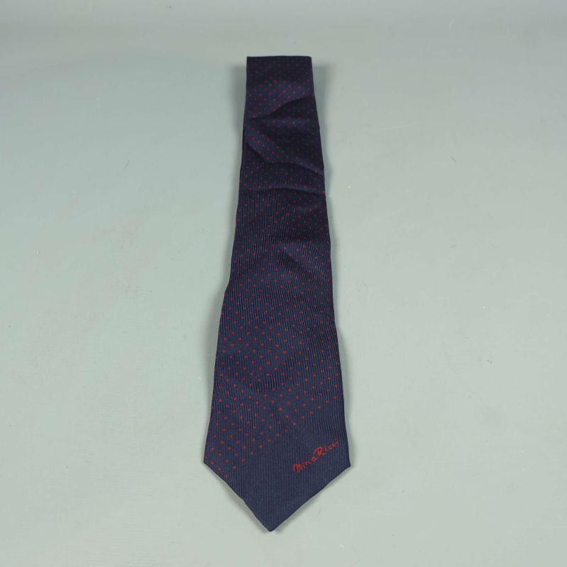 Mörkblå slips med röda prickar utlagd
