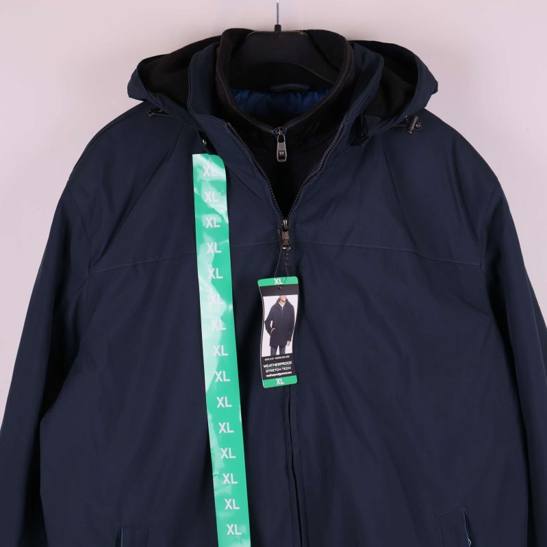 Närbild på jackans överdel med huva och XL-rem