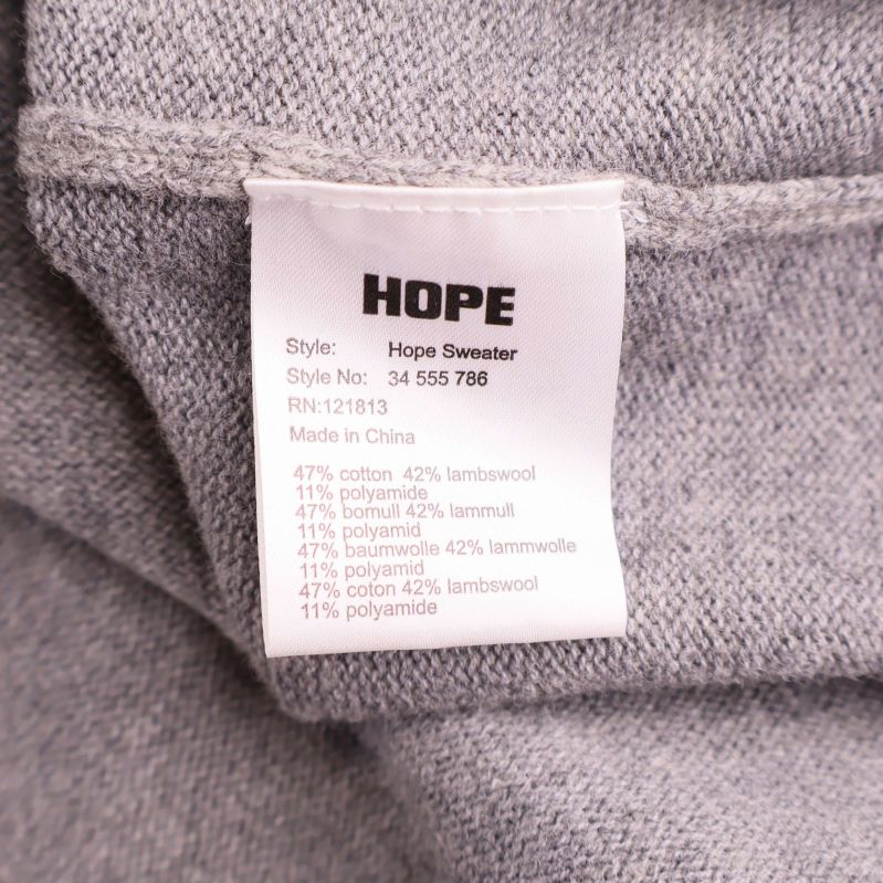 Materialetikett visar sammansättning i bomull, lammull och polyamid