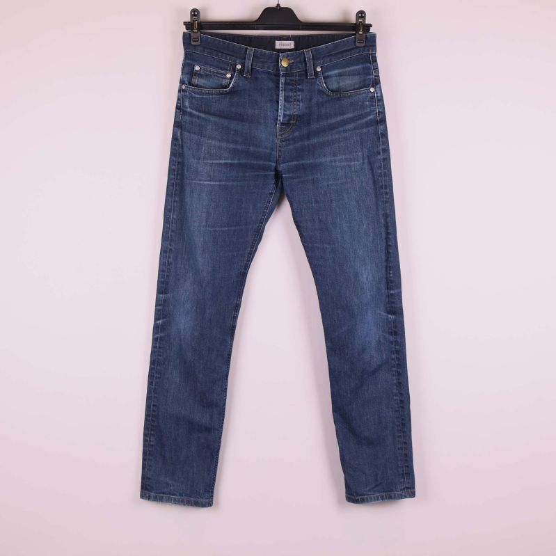 Framsida av raka blå jeans hängande på galge