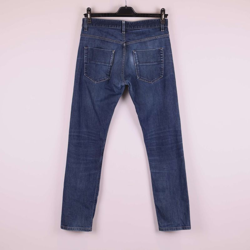 Baksida av raka blå jeans med bakfickor