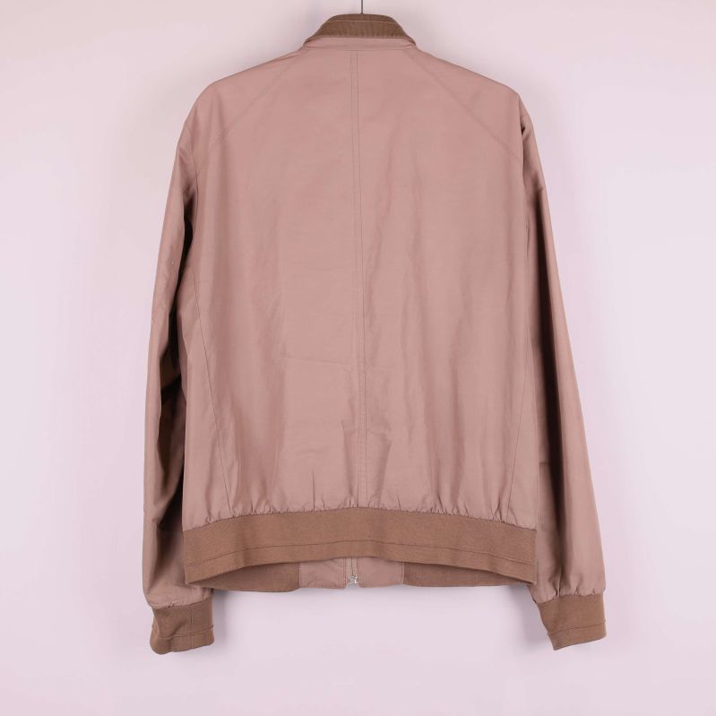 Baksidan av beige bomberjacka med ribbad nederkant