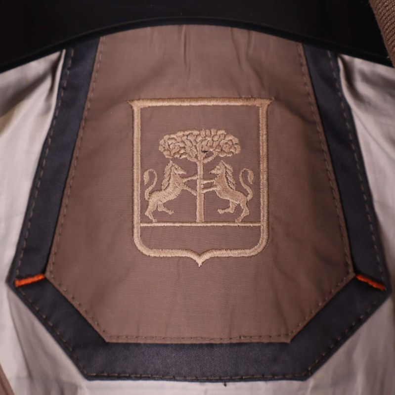 Broderat emblem med lejon och träd i nacken på jackans insida