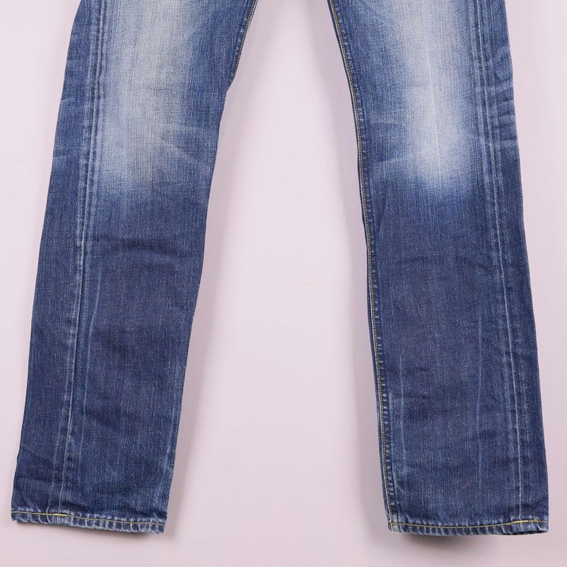 Benparti på blåa jeans med slitningsdetaljer