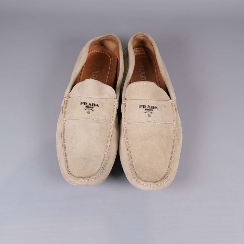 Beige mockaloafers från Prada framifrån med logotyp