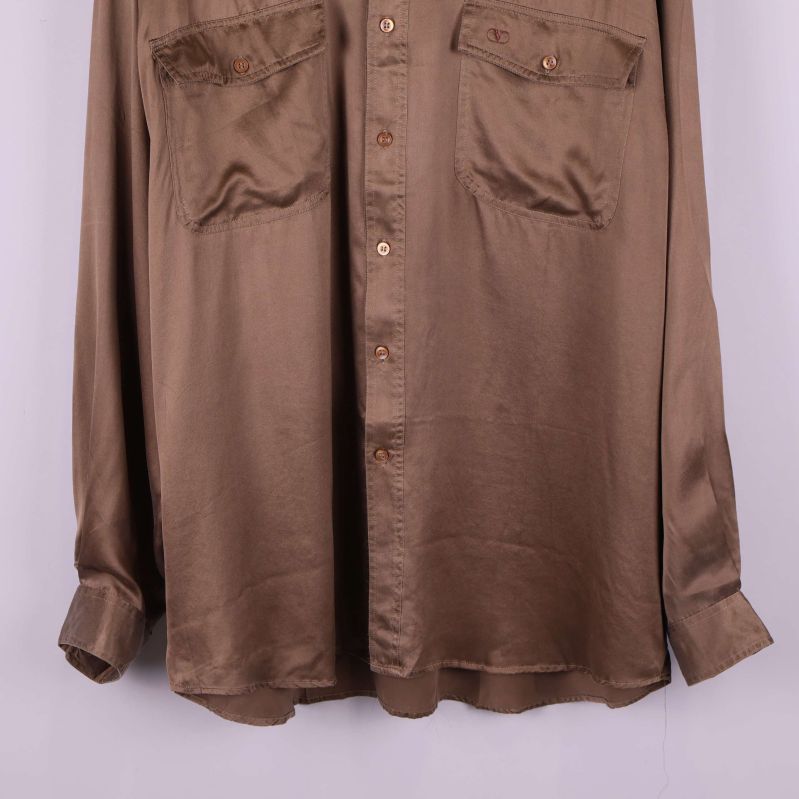 Nedre delen av brun silkesskjorta och knapprad