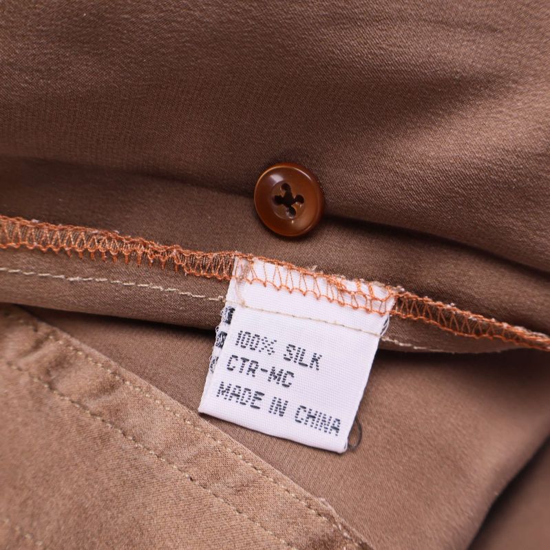 Närbild på inneretikett med texten 100% silk