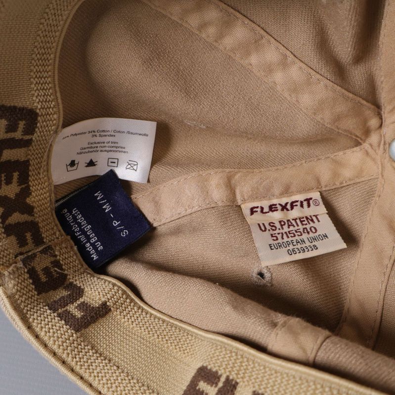 Närbild på etiketter och FLEXFIT-band inuti kepsen