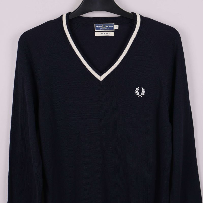 Detalj på V-ringning och bröstlogo på tröja