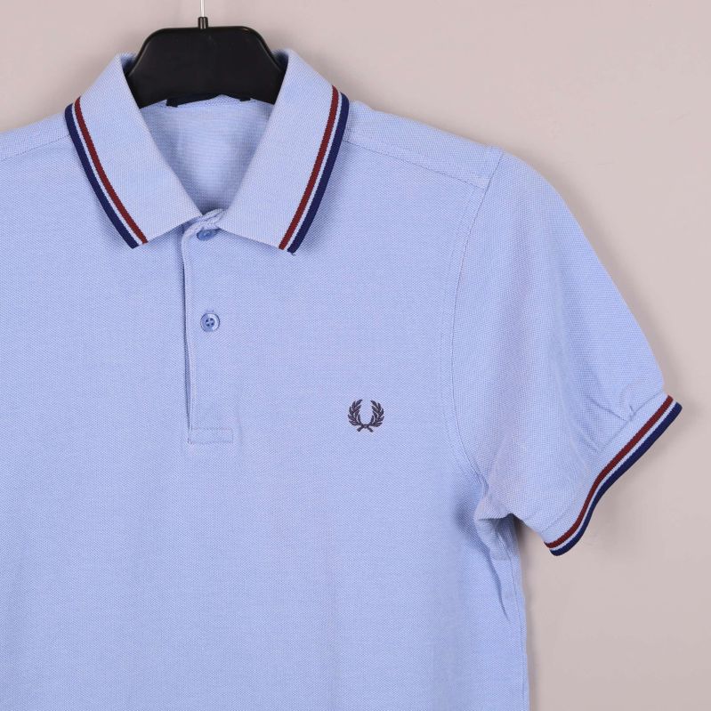 Framsida av pikétröja med knappar och brodyr