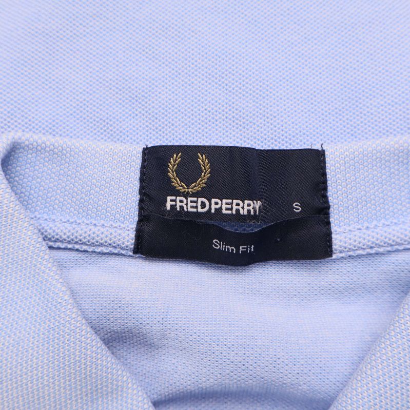 Närbild på Fred Perry-logotyp och storleksmärkning S