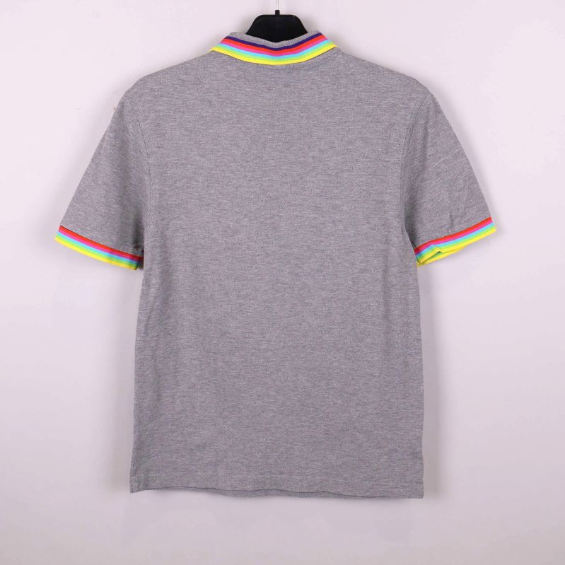 Baksidan av grå pikétröja med randiga ärmslut och krage