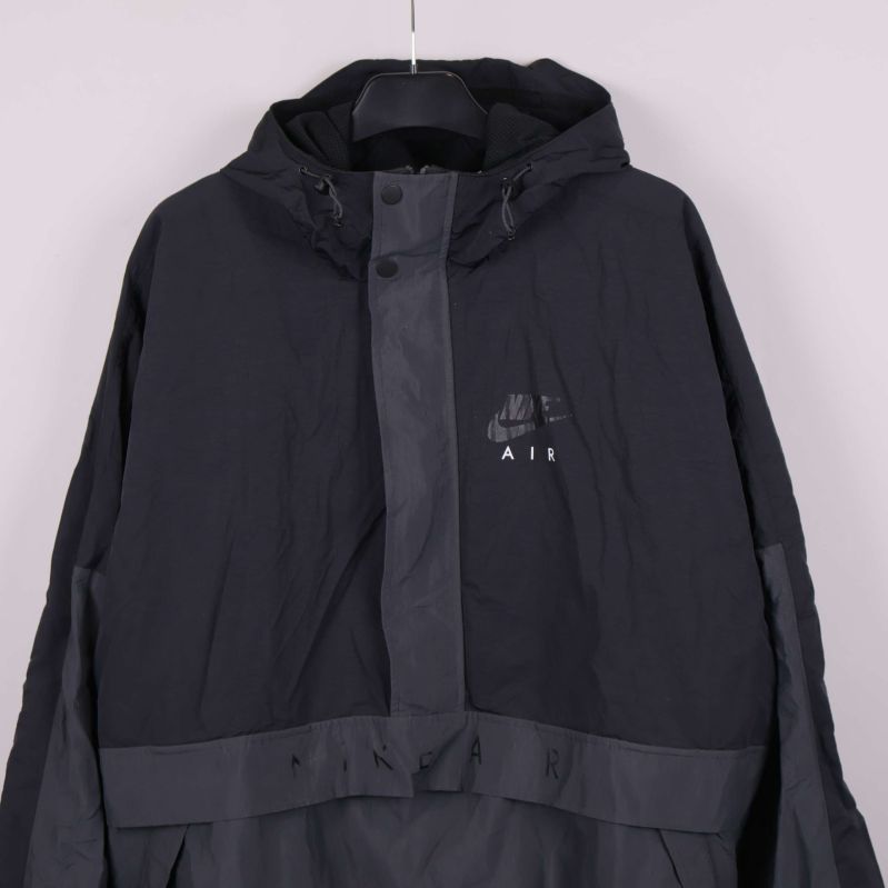 Närbild på Nike Air logotyp och tryckknappar på jackans framsida