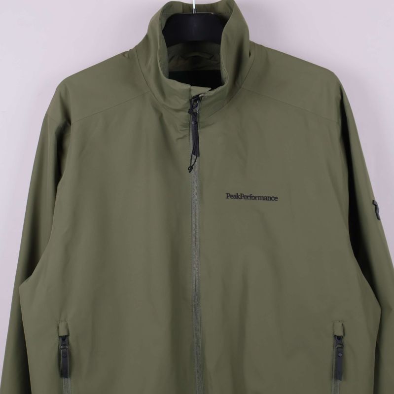 Närbild på jackans bröst med logotyp och dragkedja