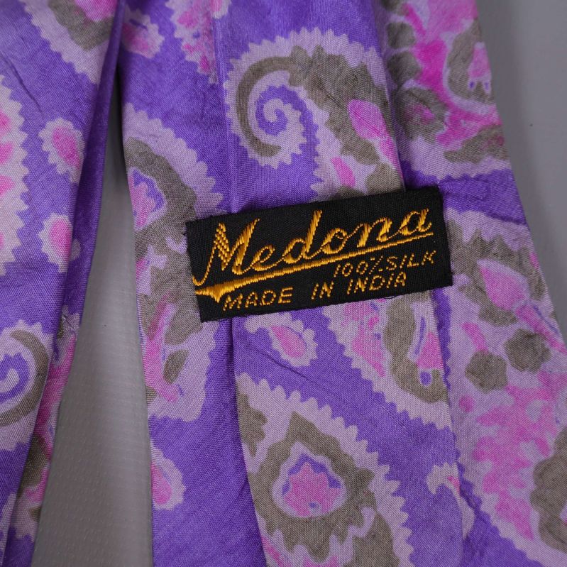 Närbild på svart etikett som anger Medona 100% silke