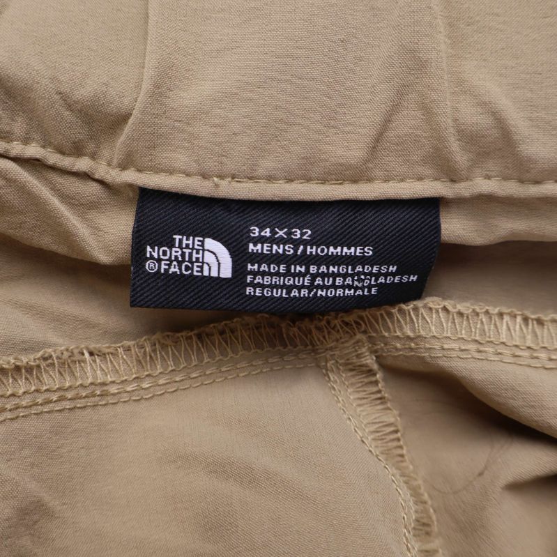Etikett från The North Face i byxans midja visar storlek 34x32