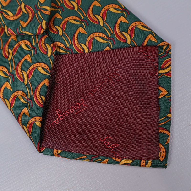 Baksidan av slipsen med vinrött foder och broderad logga