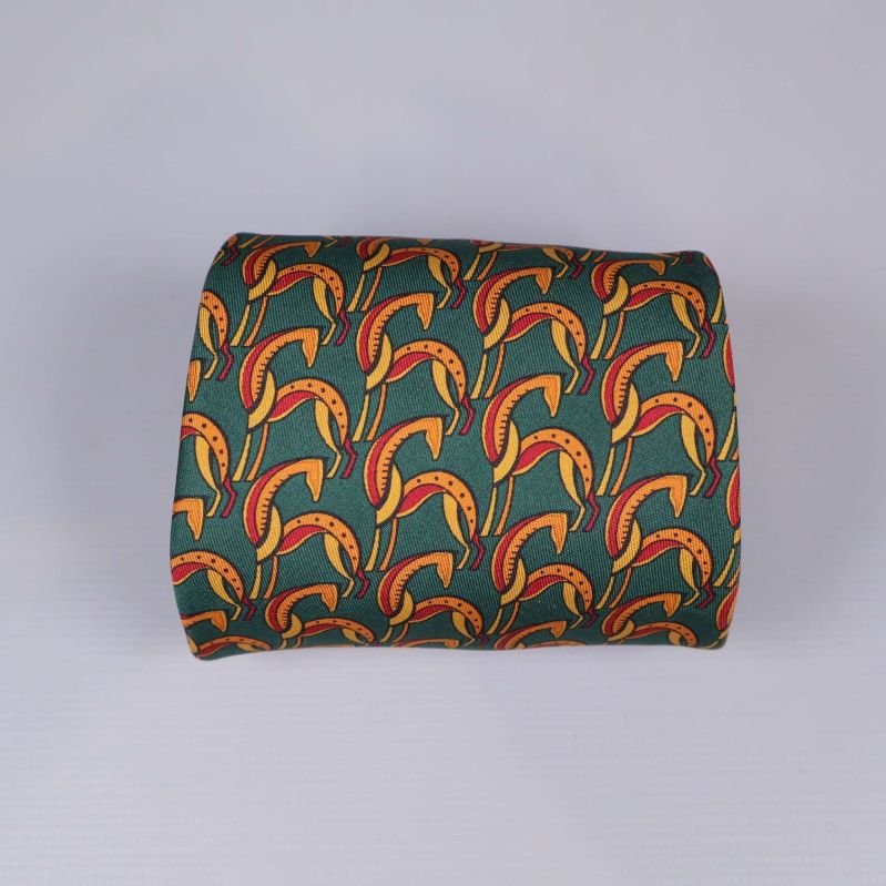 Rullad grön slips med grafiskt mönster i rött och gult