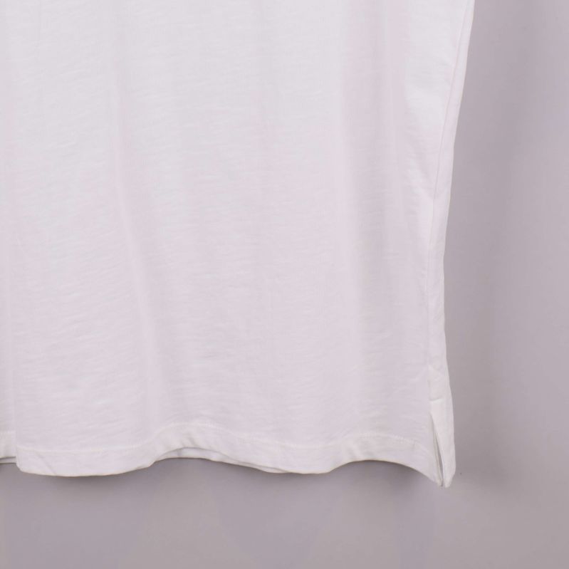 Nedre del av vit t-shirt med slits i sidan