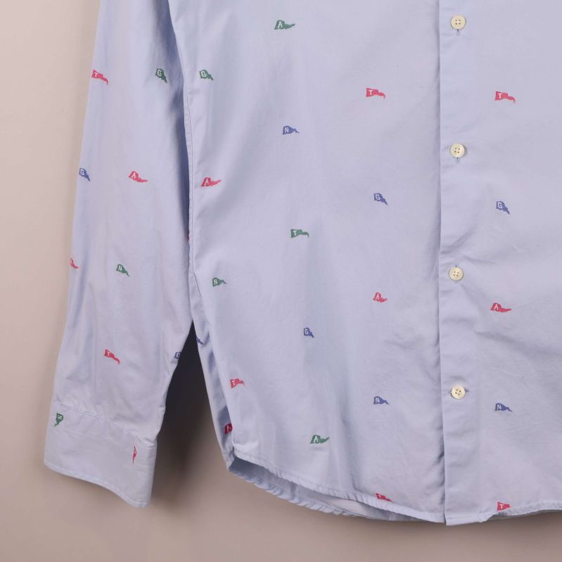 Närbild på skjortärm och nederkant med broderat mönster