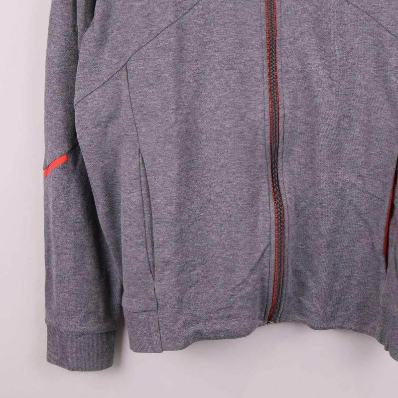 Nedre delen av grå tröja med röda detaljer