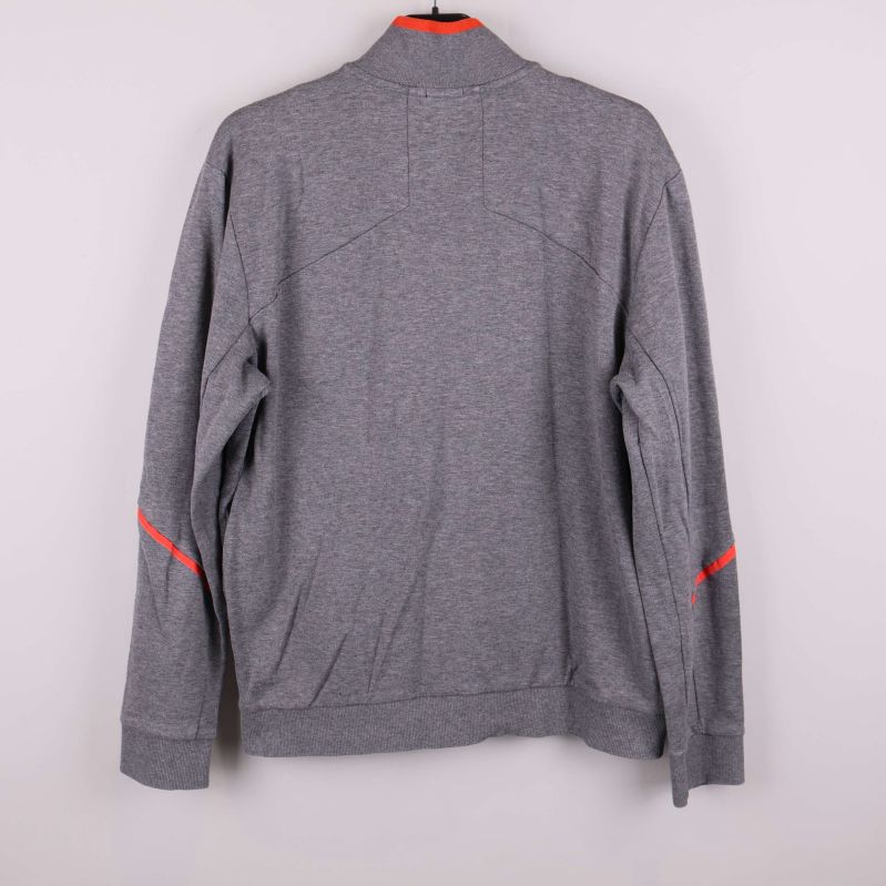 Baksida av grå ziptröja med röda detaljer på ärmarna