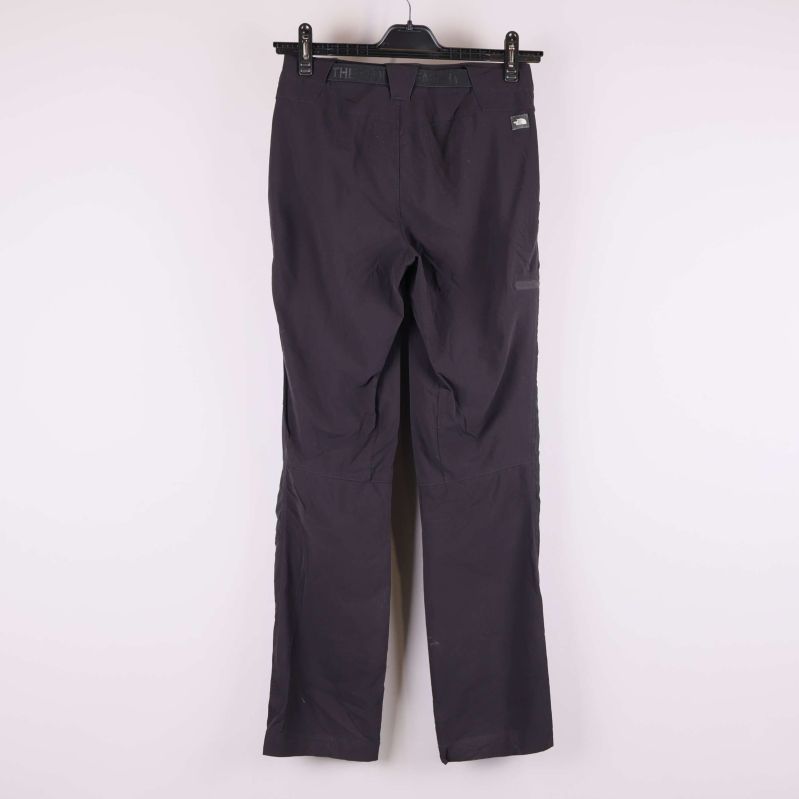 Baksidan av mörka byxor visas hängande mot ljus bakgrund