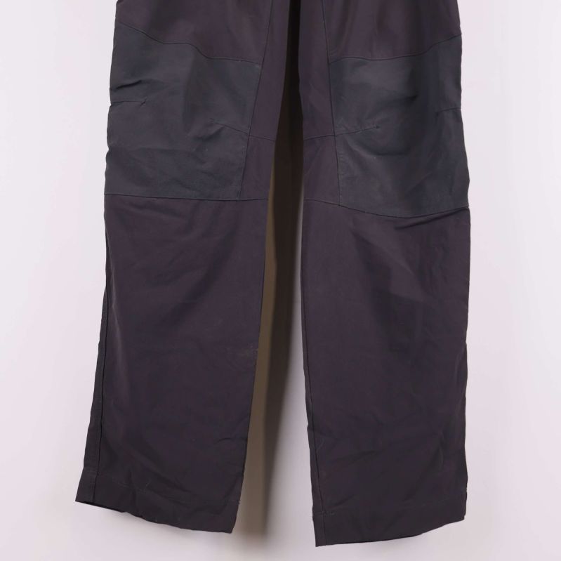 Förstärkta knäpartier på mörka byxor i närbild