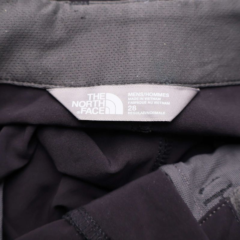 Närbild på The North Face-loggan i midjan på byxorna