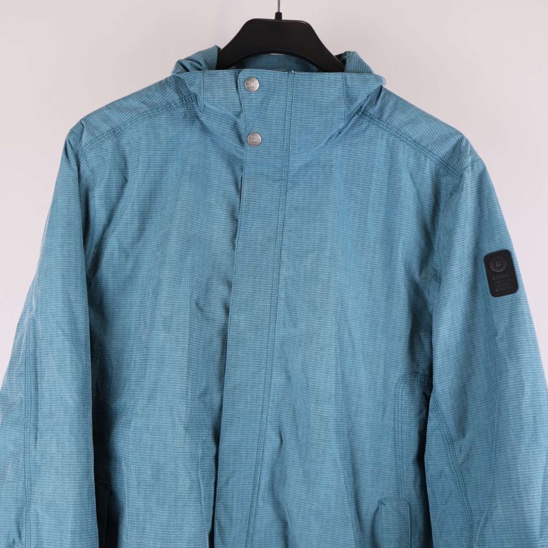 Närbild på jackans övre del med huva och knappar