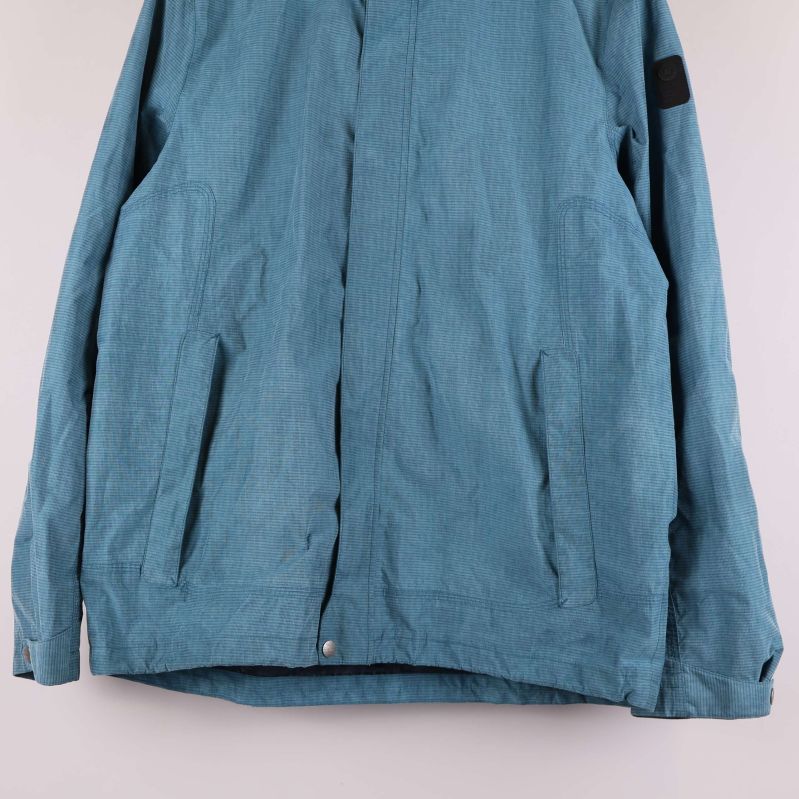 Nedre delen av jackan med fickor och knappdetaljer