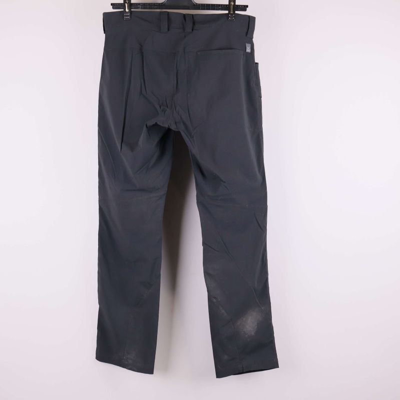 Baksida på svarta byxor mot ljus bakgrund