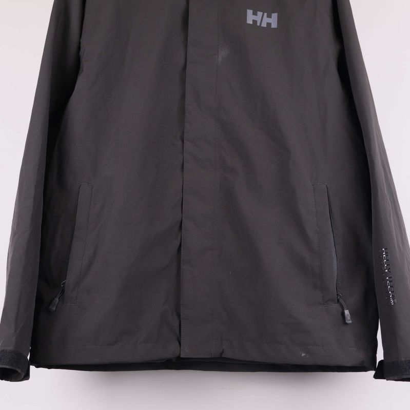 Närbild på fickor och ärmslut på svart jacka