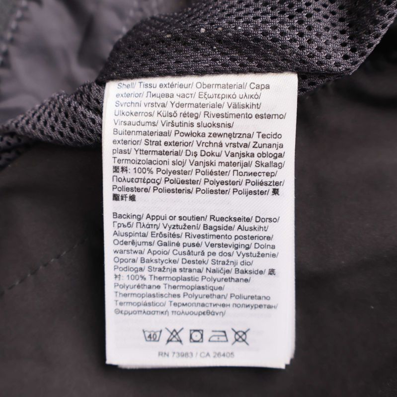 Textiletikett med materialinformation på svart jacka