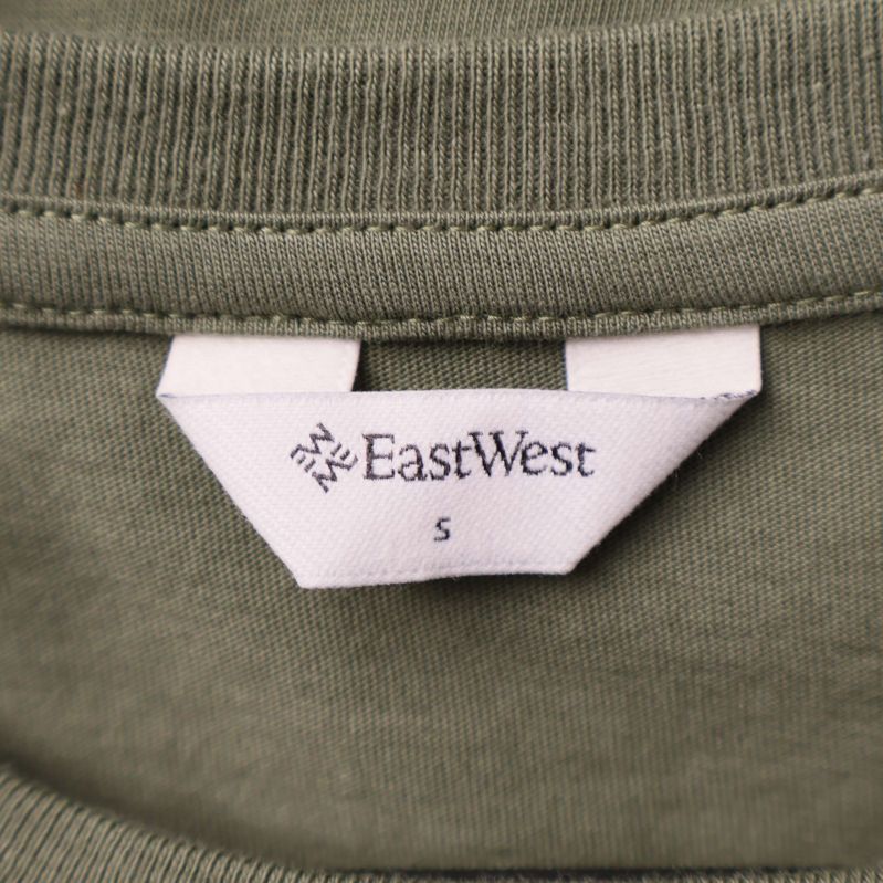Närbild av nacketikett på t-shirt med texten EastWest S