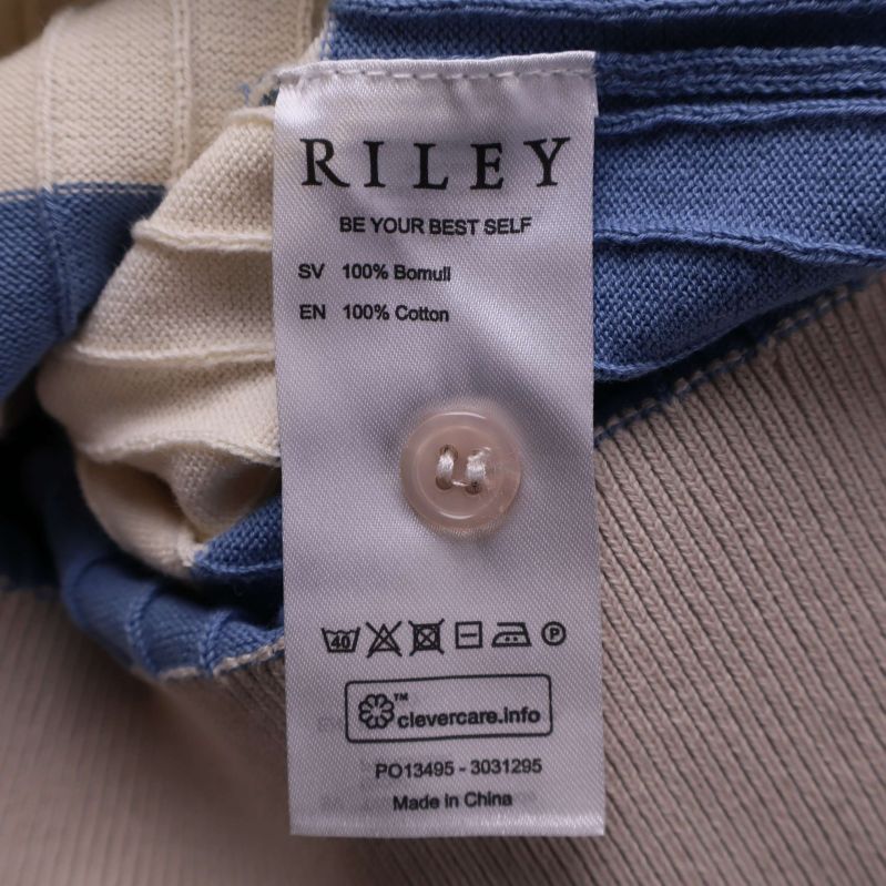 Materialetikett med information om 100% bomull och tvättråd från Riley