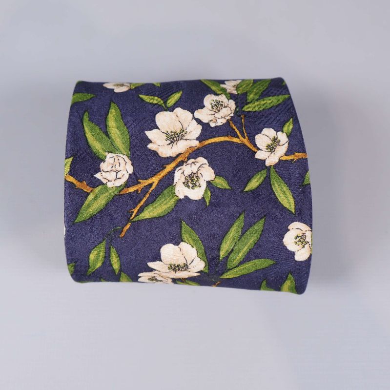 Ihoprullad slips med blommigt mönster på blå botten