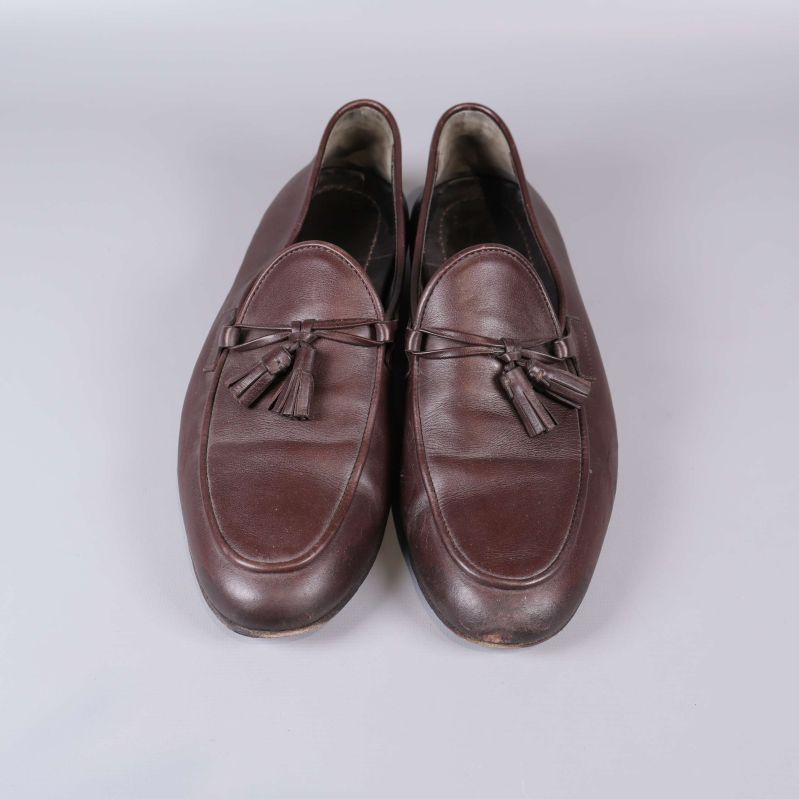 Bruna loafers med tofsar fotade framifrån ovanifrån