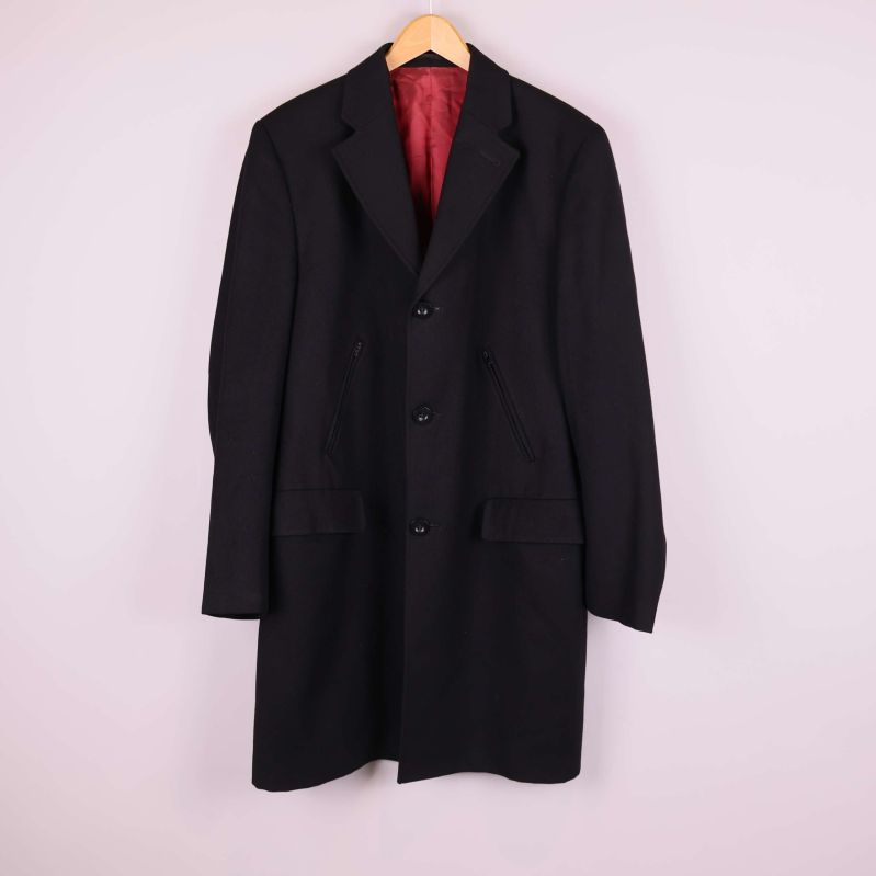 Svart ullrock på galge med rött innerfoder