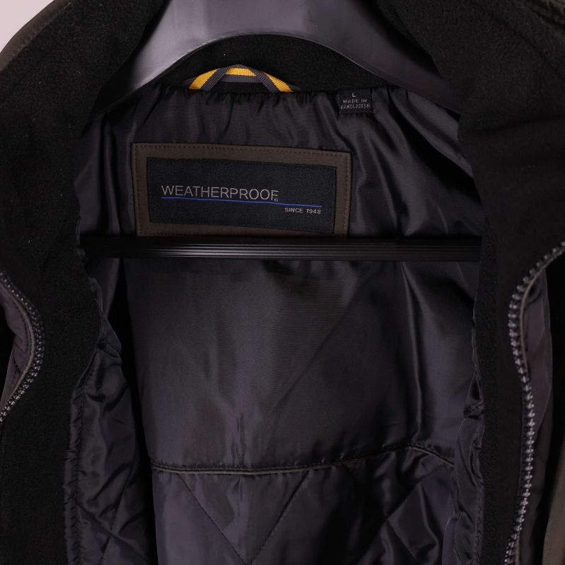 Insidan på jackan visar svart innerfoder med märkesetikett