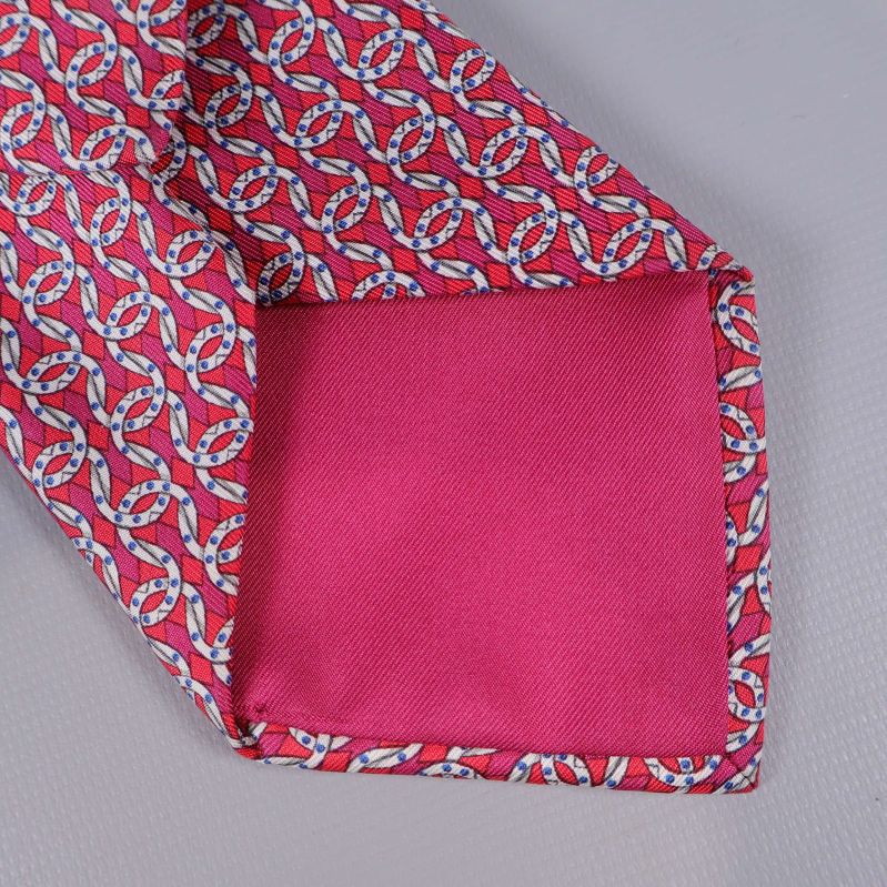 Närbild på fodrad ände i rosa tyg på Hermès slips