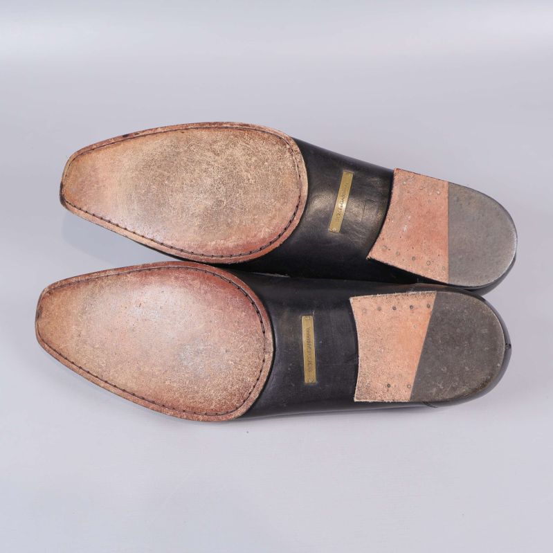 Undersida av loafers med sydda sulor och logo