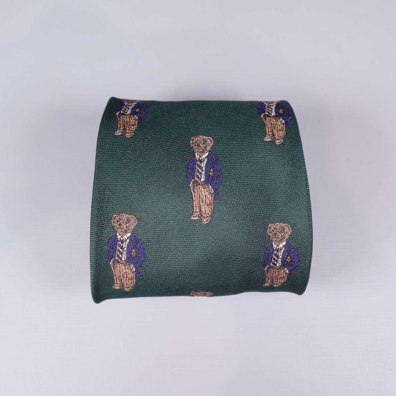 Närbild på björnmotivens broderi på den gröna slipsen