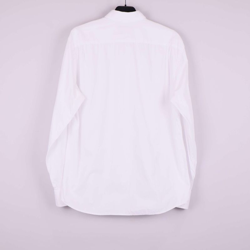 Baksidan av vit skjorta hängande på galge utan synliga detaljer