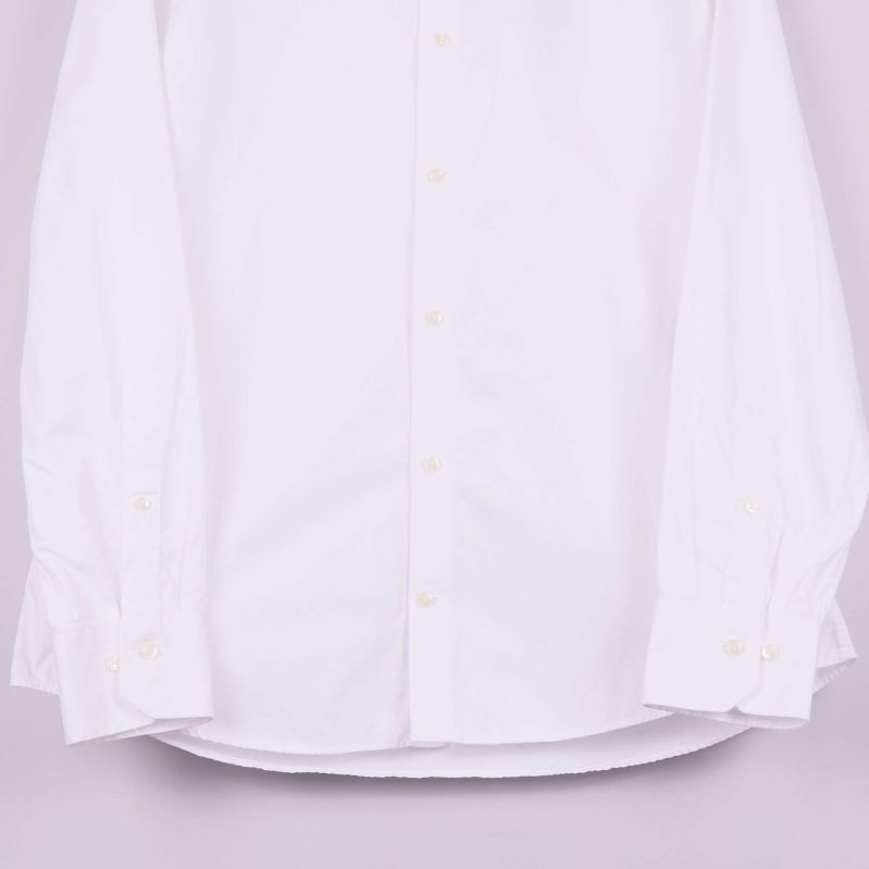 Ärmar och knappar på vit skjorta i närbild