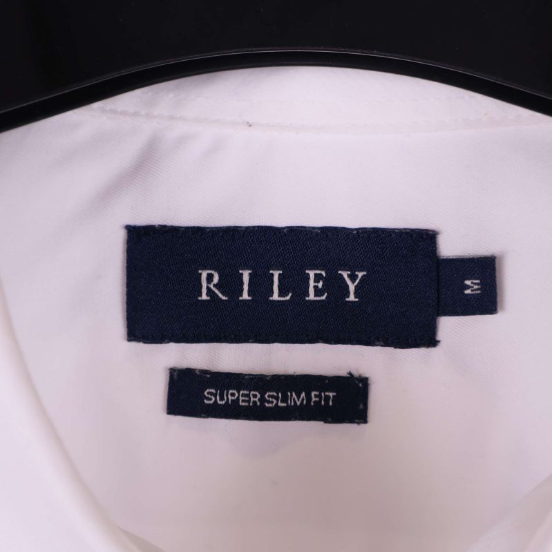 Nära bild på mörkblå Riley-etikett i skjortan