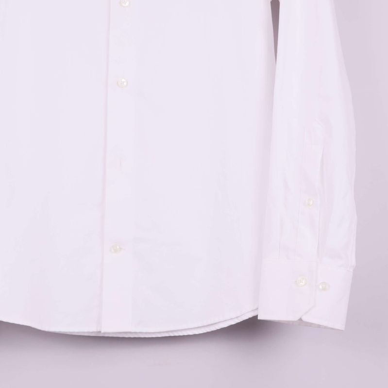 Ärmslut och knäppning på vit skjorta visas i detalj