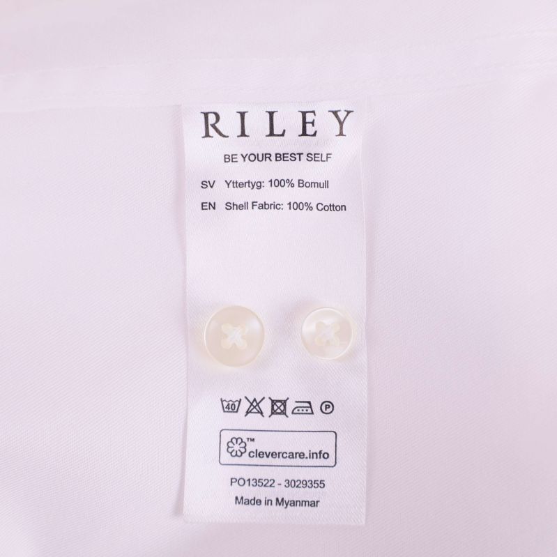 Materialetikett visar Riley och 100% bomull